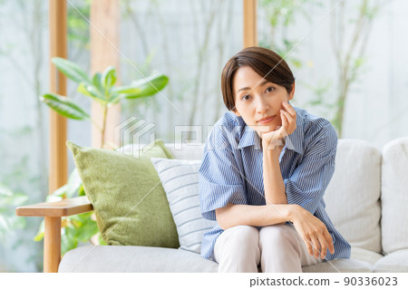 A middle-aged woman relaxing in the living room A middle-aged woman relaxing in the living room 90336023
