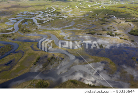 Aerial view of winding flooded river beds with ducts, during the spring flood. 90336644