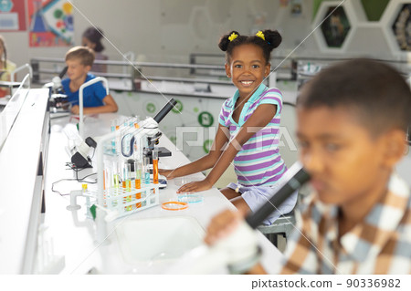 Portrait of african american elementary schoolgirl at desk in science laboratory Portrait of african american elementary schoolgirl at desk in science laboratory 90336982
