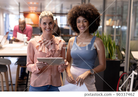 Portrait of smiling multiracial businesswomen working together at modern workplace Portrait of smiling multiracial businesswomen working together at modern workplace 90337462