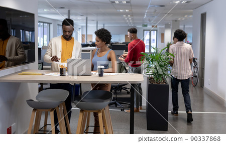 Young african american business advisors working together while standing with laptop at workplace 90337868
