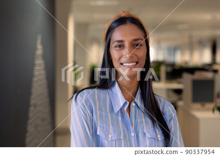 Portrait of smiling beautiful young african american businesswoman with long black hair at workplace Portrait of smiling beautiful young african american businesswoman with long black hair at workplace 90337954