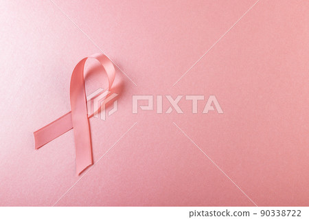 Directly above shot of pink breast cancer awareness ribbon against pink background, copy space 90338722
