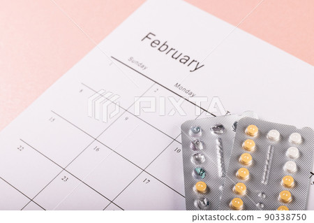 High angle close-up of blister packs of medicines with medication calendar on table, copy space 90338750