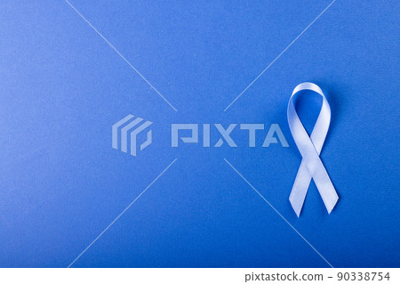 Directly above shot of stomach cancer awareness blue ribbon isolated against blue background Directly above shot of stomach cancer awareness blue ribbon isolated against blue background 90338754
