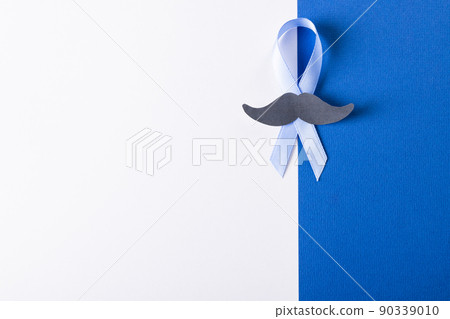 Directly above shot of blue prostate cancer awareness ribbon with mustache on white, blue background Directly above shot of blue prostate cancer awareness ribbon with mustache on white, blue background 90339010