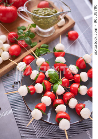 Caprese salad - Mini mozzarella cheese in glass bowl, tomato and basil Caprese salad - Mini mozzarella cheese in glass bowl, tomato and basil 90339790