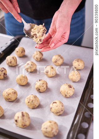 Woman holding ball of raw dough while making Chocolate chip cookies 90339800