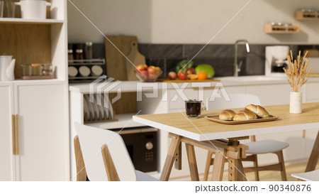 Minimal wooden dining table over blurred modern kitchen cooking space in the background. 90340876