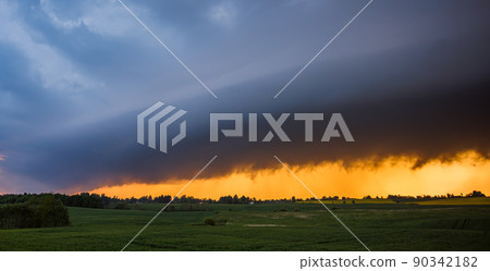 Storm cloud in the sunset light, shelf cloud with dramatic light Storm cloud in the sunset light, shelf cloud with dramatic light 90342182