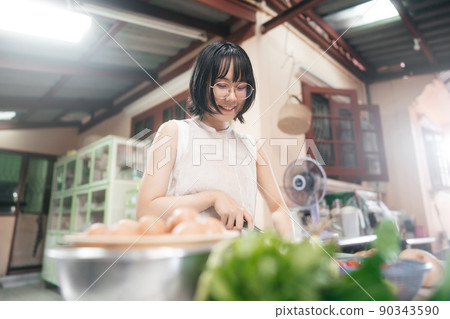 Happy young adult asian woman leisure with cooking in kitchen on day. 90343590