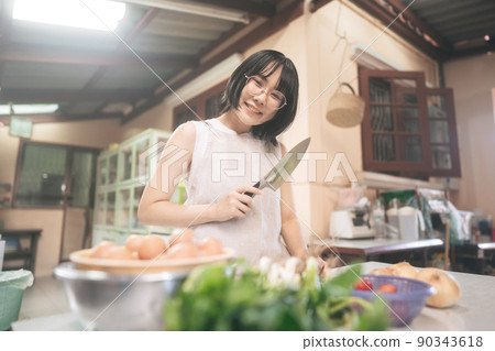 Happy young adult asian woman leisure with cooking in kitchen on day. 90343618