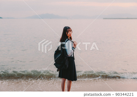 Schoolgirl in uniform and beautiful sunset sky 90344221
