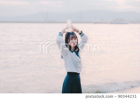 Schoolgirl in uniform and beautiful sunset sky Schoolgirl in uniform and beautiful sunset sky 90344231