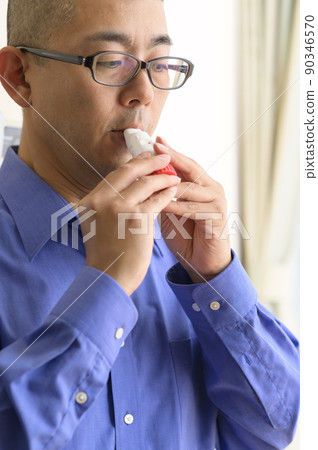 Men using asthma inhalers Men using asthma inhalers 90346570