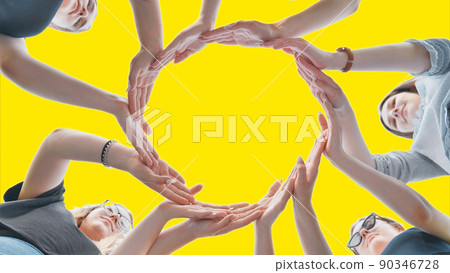 Friends make a circle with their palms on a yellow background. Friends make a circle with their palms on a yellow background. 90346728