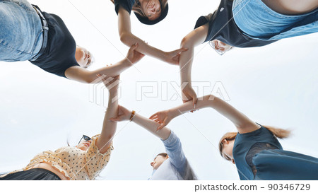 The girlfriends join the wrists in the center making a circle shape. The girlfriends join the wrists in the center making a circle shape. 90346729