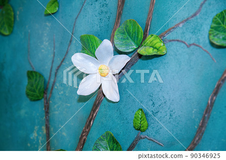 Handmade interior detail - flowers made of self-hardening modelling clay on a rough wall. Handmade interior detail - flowers made of self-hardening modelling clay on a rough wall. 90346925