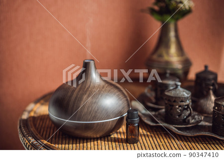 Aroma oil diffuser with aroma oil on table at home. Air freshener Aroma oil diffuser with aroma oil on table at home. Air freshener 90347410