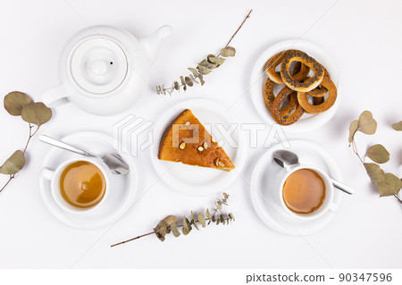 white tea set with teapot tea and saucers and pie for breakfast 90347596