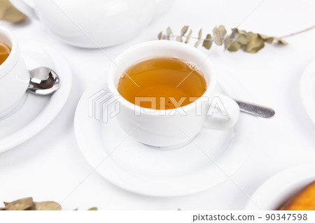 white porcelain cup with tea for tomorrow on the table with a saucer white porcelain cup with tea for tomorrow on the table with a saucer 90347598