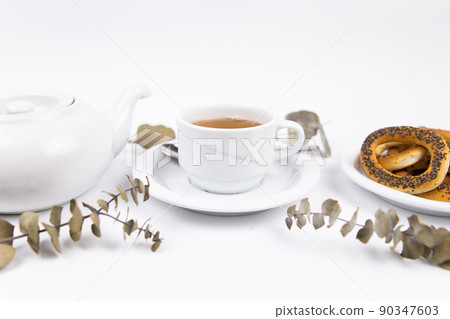 white porcelain cup with tea for tomorrow on the table with a saucer white porcelain cup with tea for tomorrow on the table with a saucer 90347603