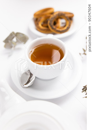 white porcelain cup with tea for tomorrow on the table with a saucer white porcelain cup with tea for tomorrow on the table with a saucer 90347604