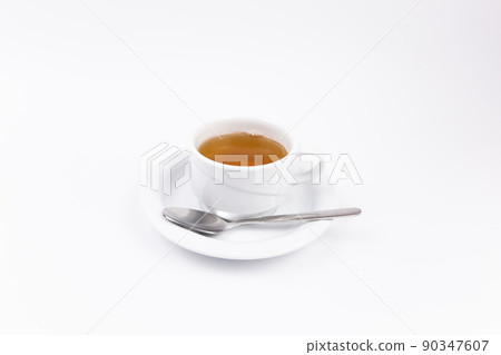 white porcelain cup with tea for tomorrow on the table with a saucer white porcelain cup with tea for tomorrow on the table with a saucer 90347607