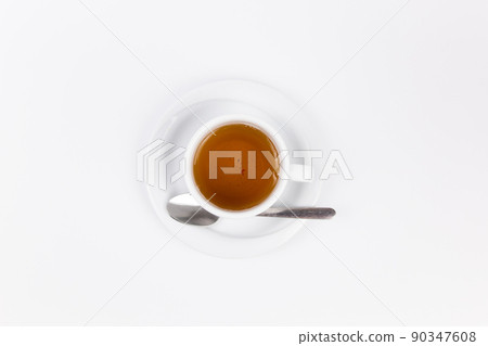 white porcelain cup with tea for tomorrow on the table with a saucer 90347608