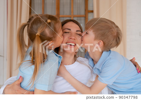 Tender loving mother with son and daughter, children kids hug mom and kiss her 90347798
