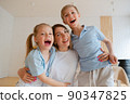 Two children son and daughter hug their mother. Happy loving family standing 90347825