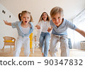 Happy mother with children, small son and daughter running towards 90347832