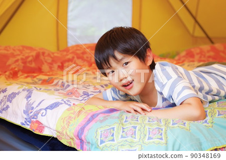 A boy relaxing in a glamping tent A boy relaxing in a glamping tent 90348169