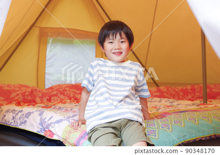 A boy relaxing in a glamping tent A boy relaxing in a glamping tent 90348170