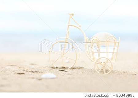A three-wheeled bicycle on the beach and a transparent globe figurine A three-wheeled bicycle on the beach and a transparent globe figurine 90349995