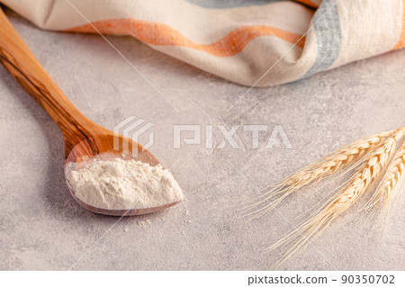 Ingredients for baking - spoon with flour, ears of wheat 90350702
