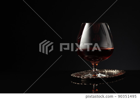 Snifter of brandy on a on a silver tray. Snifter of brandy on a on a silver tray. 90351495