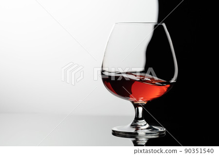 Splash of brandy in a snifter glass. 90351540