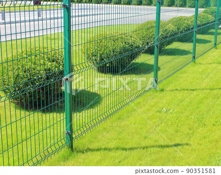 neat fence and trimmed lawn of the adjacent territory 90351581