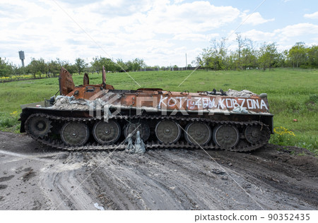A burnt Russian tank near a residential building. War in Ukraine 2022. Russian missiles in Kharkiv countryside Ukraine. Russian aggression, conflict. Russian attack on Ukraine. Russia is bombing Ukrai A burnt Russian tank near a residential building. War in Ukraine 2022. Russian missiles in Kharkiv countryside Ukraine. Russian aggression, conflict. Russian attack on Ukraine. Russia is bombing Ukrai 90352435