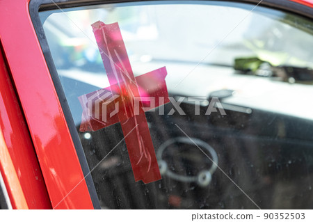 Red cross on the glass of the car. Volunteer help. Medical service. Delivery of food and medicine to people affected by the Russian invasion of Ukraine. Selective focus Red cross on the glass of the car. Volunteer help. Medical service. Delivery of food and medicine to people affected by the Russian invasion of Ukraine. Selective focus 90352503
