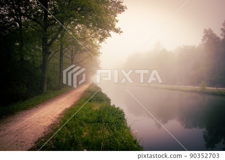 Beautiful spring sunrise over river banks. Morning fog in the forest 90352703