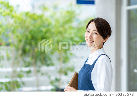 在咖啡館前歡迎顧客的中年婦女 在咖啡館前歡迎顧客的中年婦女 90353578