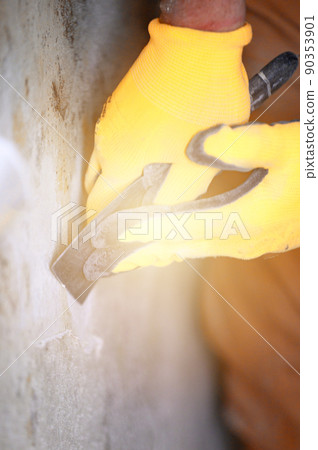 Fungus and mold is a manifestation of excess moisture in the room, a man with a spatula removes fungus and mold from the wall. Fungus and mold is a manifestation of excess moisture in the room, a man with a spatula removes fungus and mold from the wall. 90353901