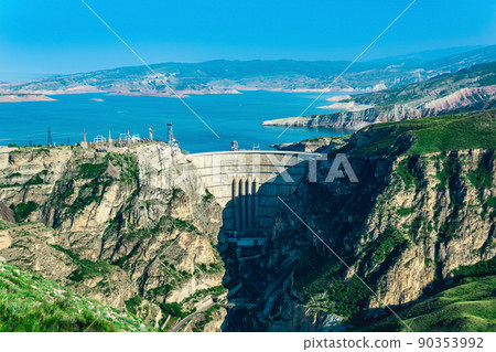 mountain landscape with an arched hydroelectric dam and a reservoir in the canyon 90353992