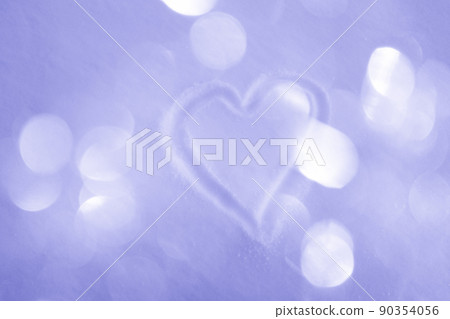 Hand-drawn heart on snowy surface with warm glittering bokeh background, toned very peri 90354056