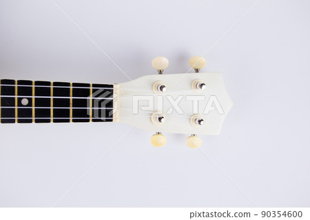 strings of a beautiful white guitar close-up on a white background ukulele strings of a beautiful white guitar close-up on a white background ukulele 90354600
