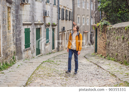Man tourist on background of Scenic panorama view of the historic town of Risan at famous Bay of Kotor on a beautiful sunny day with blue sky and clouds in summer, Montenegro, southern Europe 90355331
