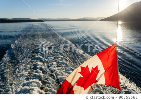Ferry sailing on the ocean. Canadian flag and waves. Southern Gulf Islands, Strait of Georgia. Ferry sailing on the ocean. Canadian flag and waves. Southern Gulf Islands, Strait of Georgia. 90355563