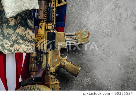 U.S. battle flag and assault rifle near the wall. close up. U.S. battle flag and assault rifle near the wall. close up. 90355584